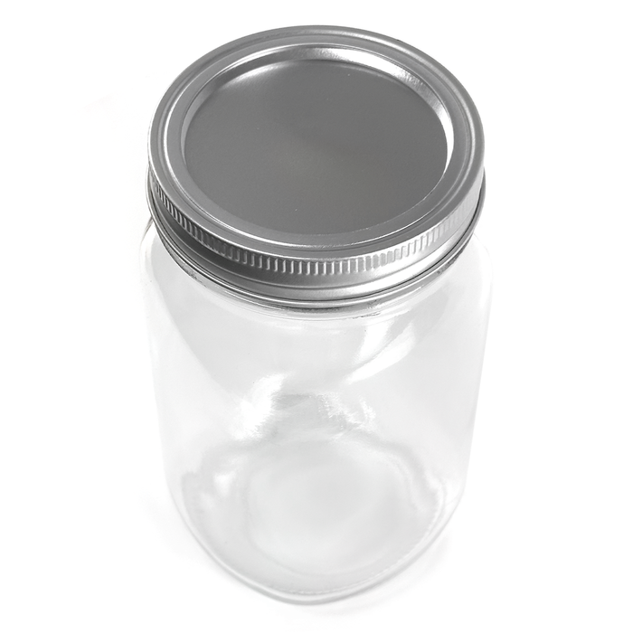Clear glass jar with a silver lid on a white background
